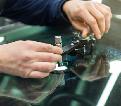 Extérieur, technicien en combinaison grise utilisant ventouses professionnelles pour installer pare-brise automobile